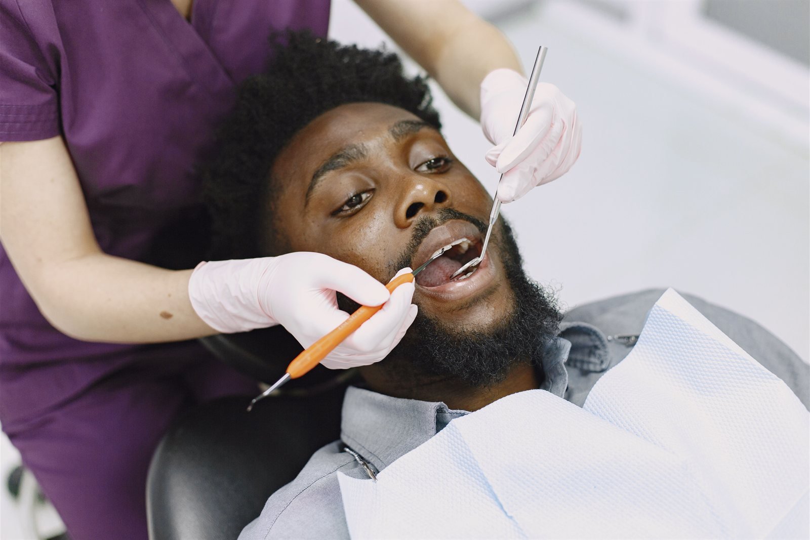 Periodontist performing a routine oral cancer screening exam at LA Periodontics