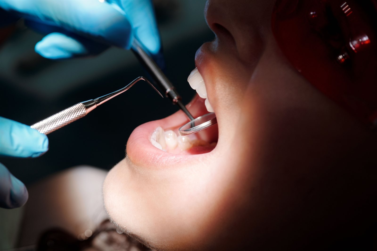 Periodontist performing an oral pathology screening exam in Los Angeles